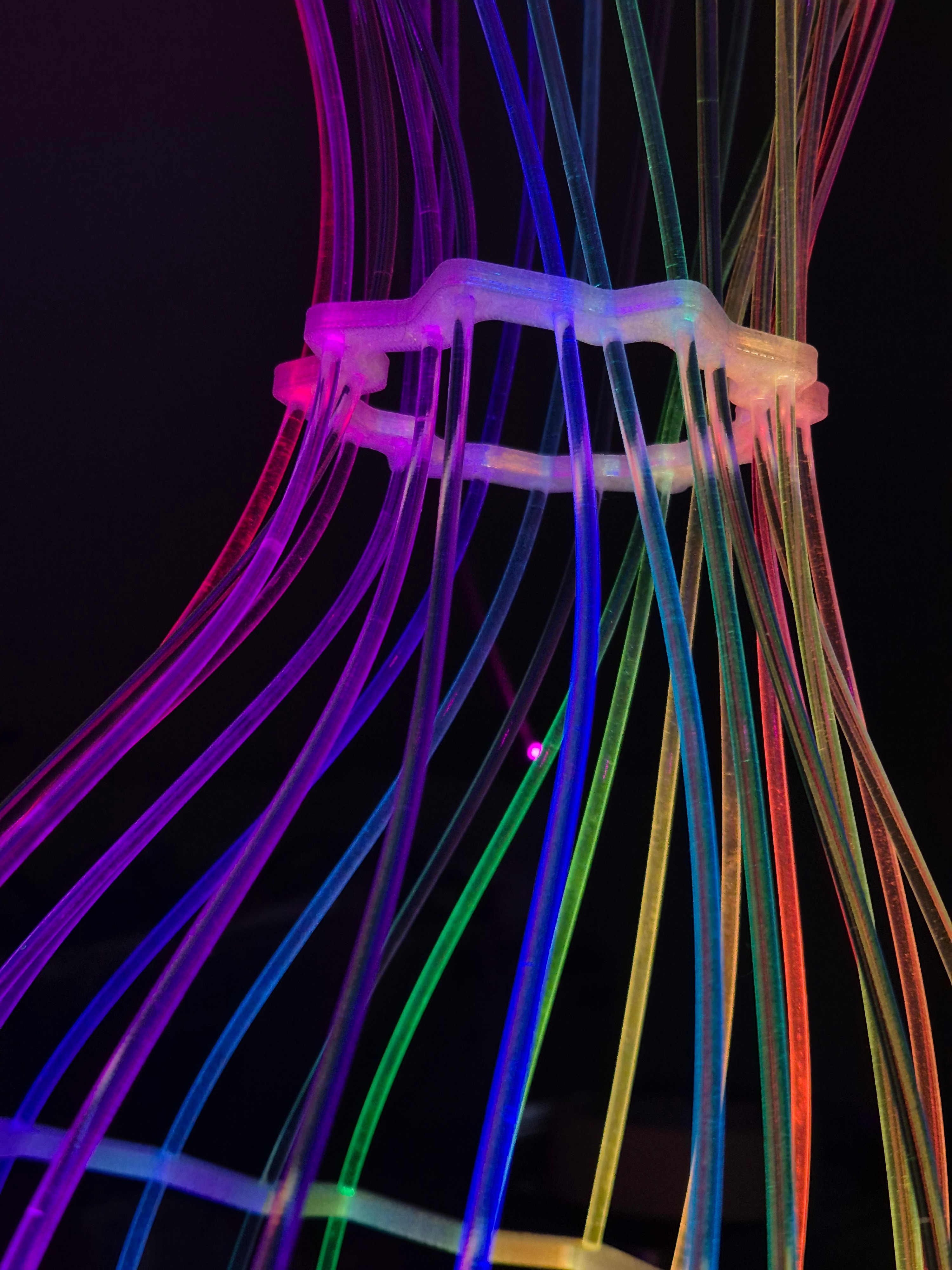 Fiberina — detail duhových optických vláken držených 3D tištěnou objímkou