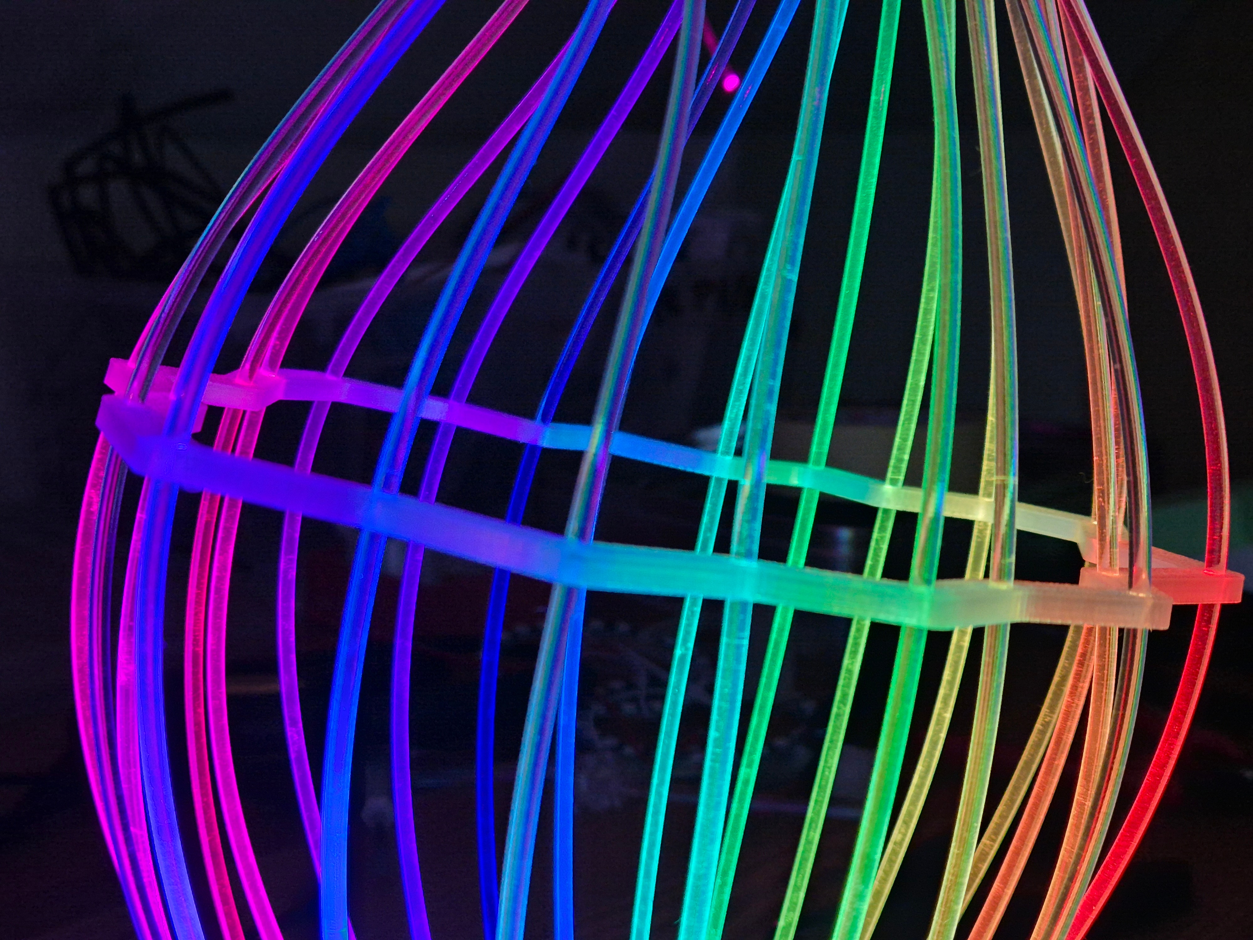 Fiberina — detail duhové světelné sochy v klecové struktuře