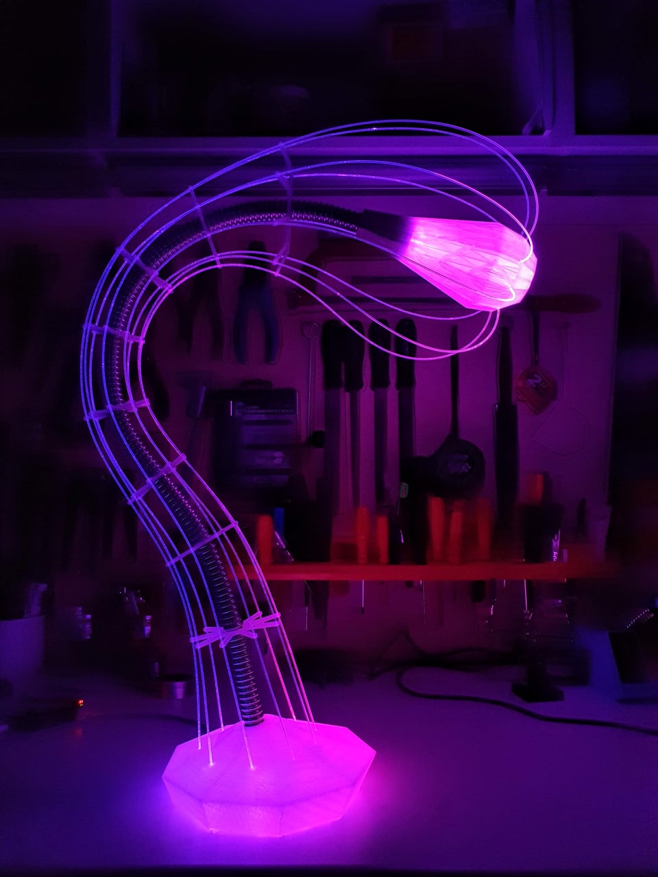 IXFID — fialová svítící zakřivená stolní lampa v dílně